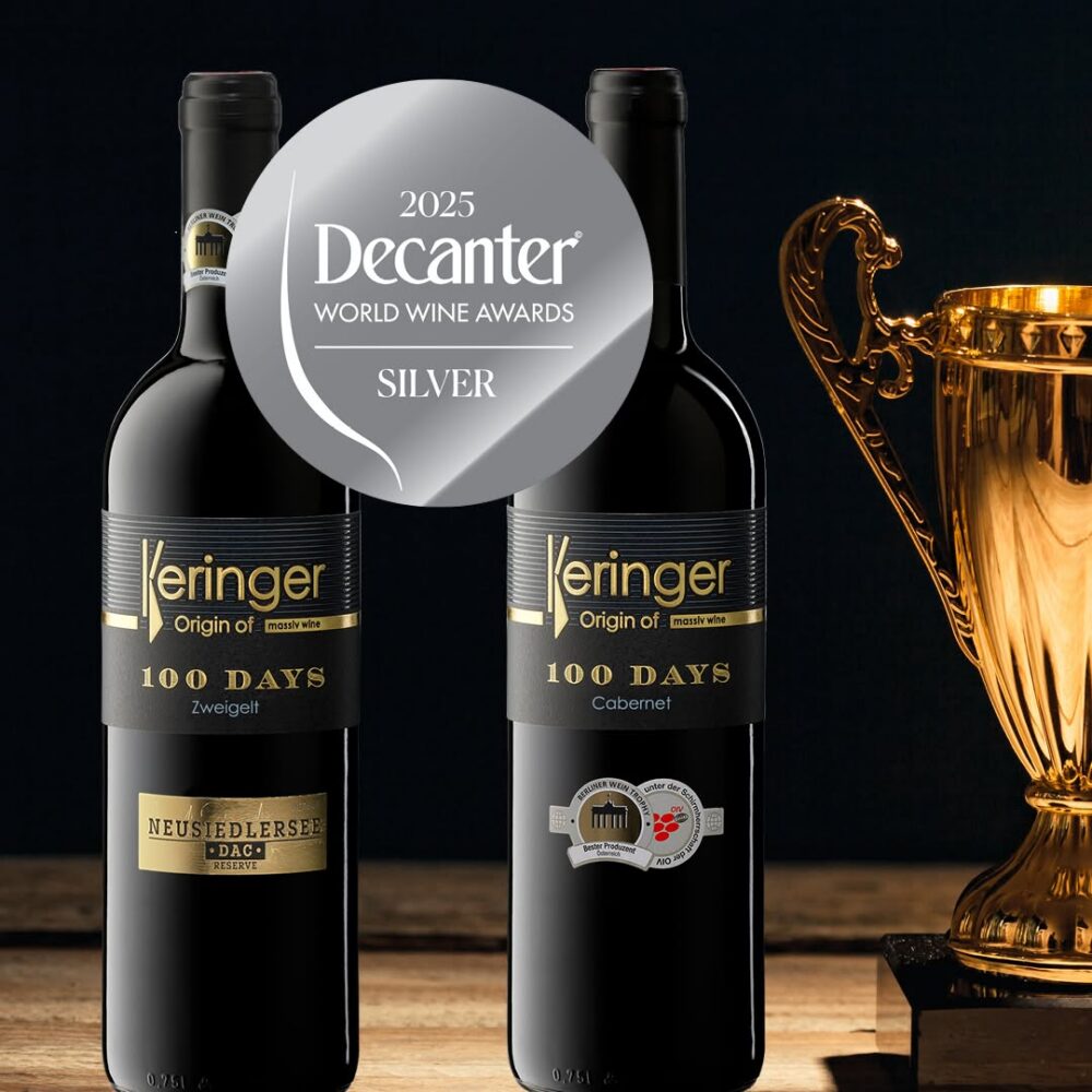 100 DAYS Zweigelt und 100 DAYS Cabernet Flaschenfoto mit Auszeichnung Decanter World Wine Awards 2025 und Pokal im Hintergrund, Weingut Keringer