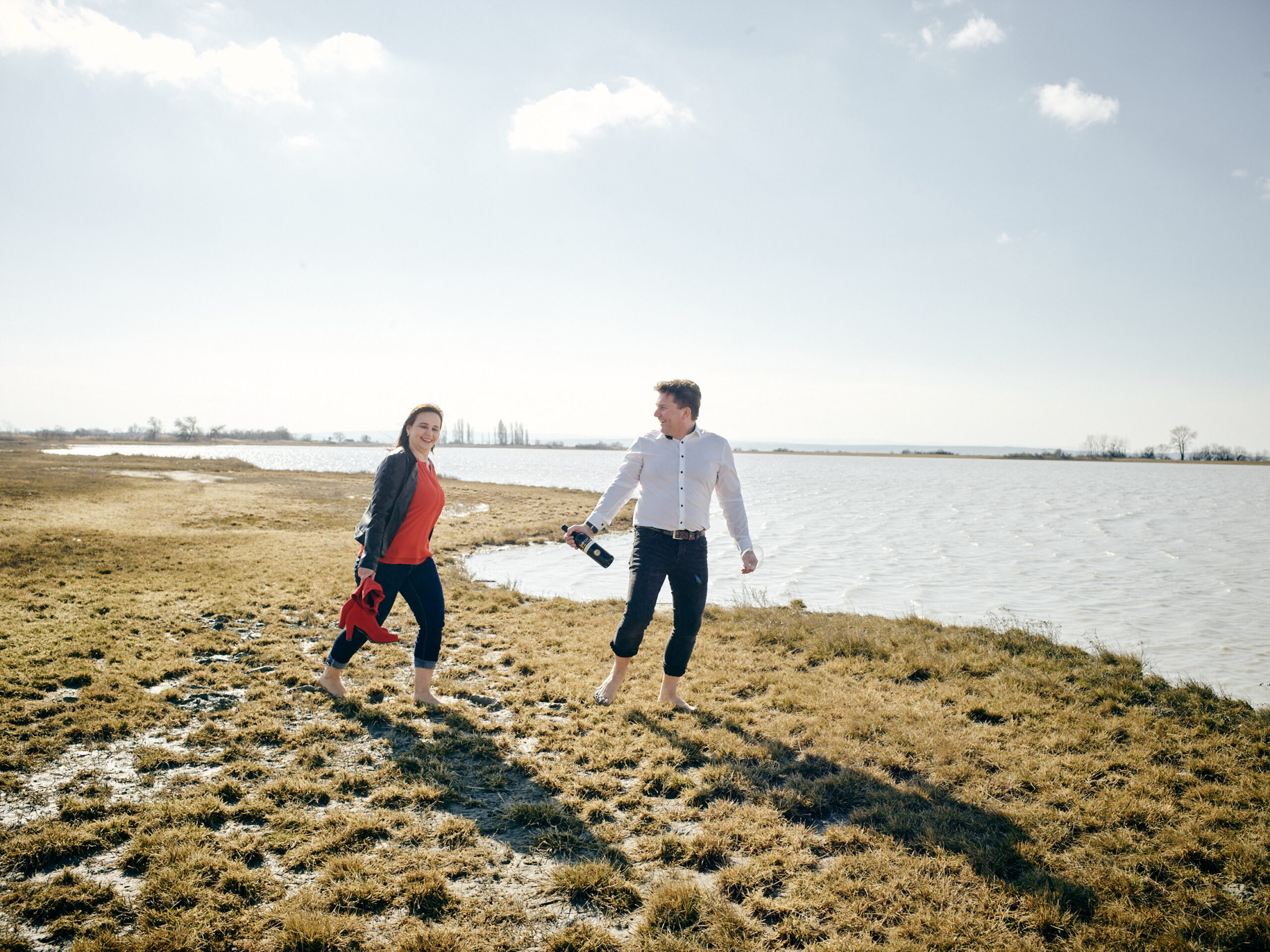 Marietta und Robert Keringer gehen durch die Landschaft des Neusiedlersee DAC Gebiets, die Region, in der ihr Weingut und ihr Leben beheimatet ist.
