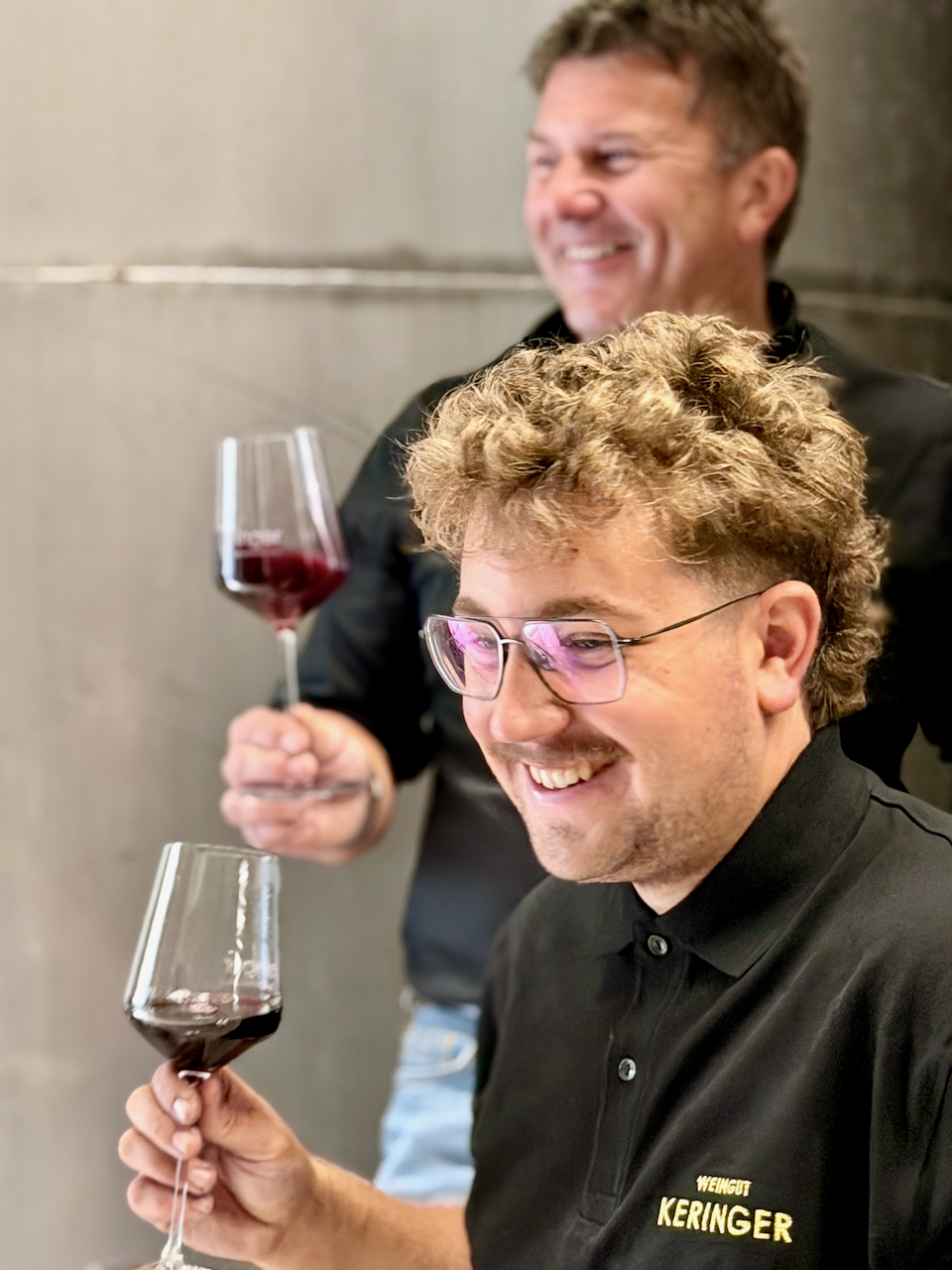 Robert und Jonas Keringer im Weinkeller mit Weinglas